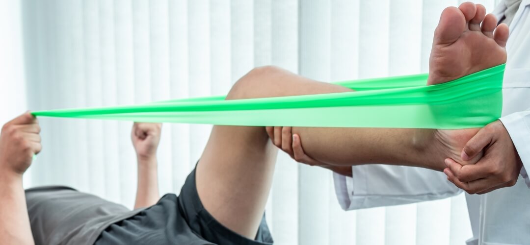 Leg flexibility physiotherapy with green resistance band