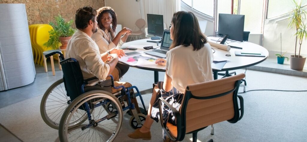 Group of people around a table with one in a wheelchair